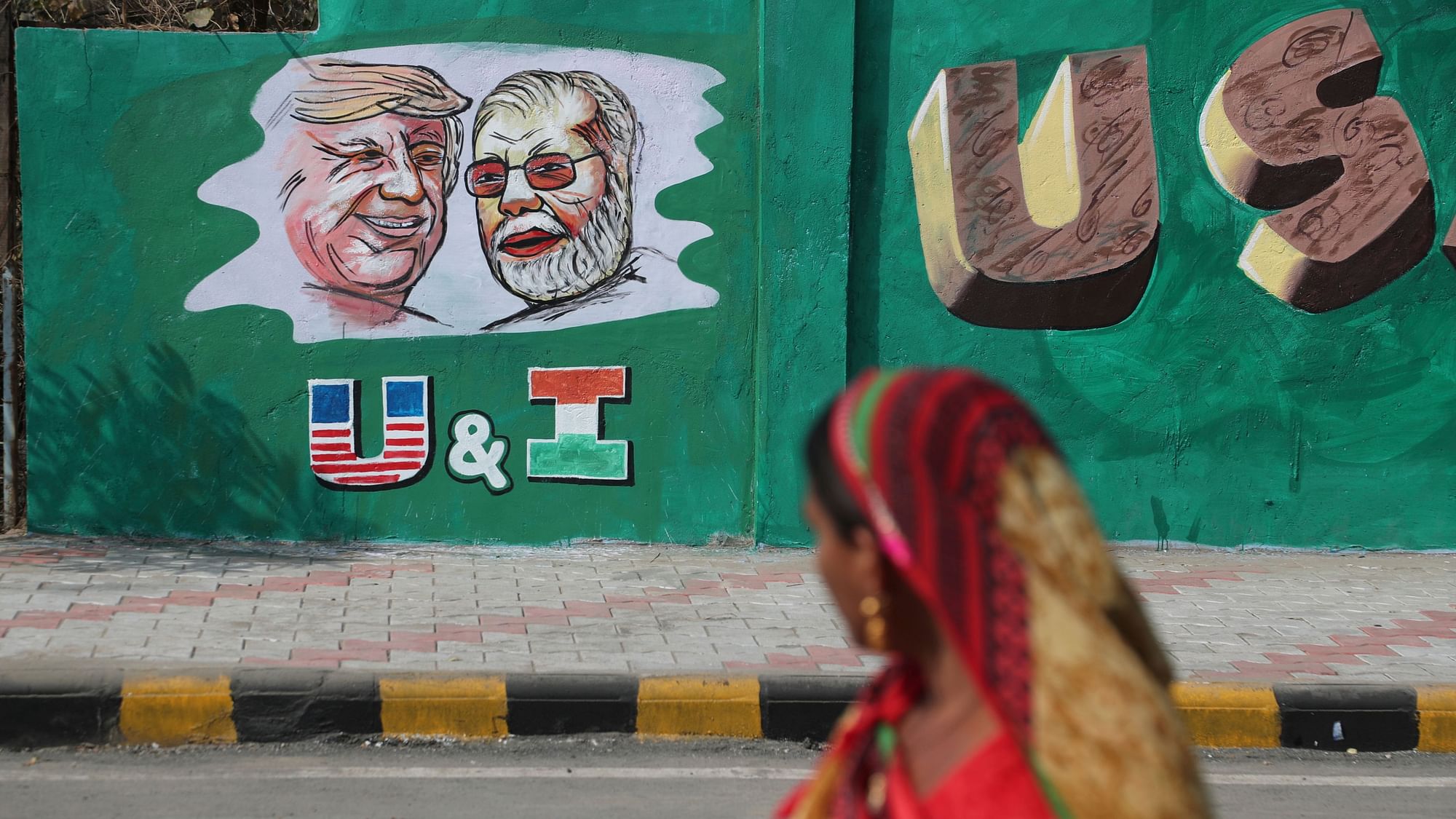An Indian woman looks at a wall painted with portraits of US President Donald Trump and Indian Prime Minister Narendra Modi ahead of Trump’s visit, in Ahmadabad, on Tuesday, 18 February.