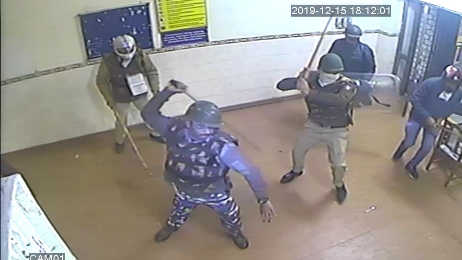 Armed policemen enter the reading hall and beat up students.