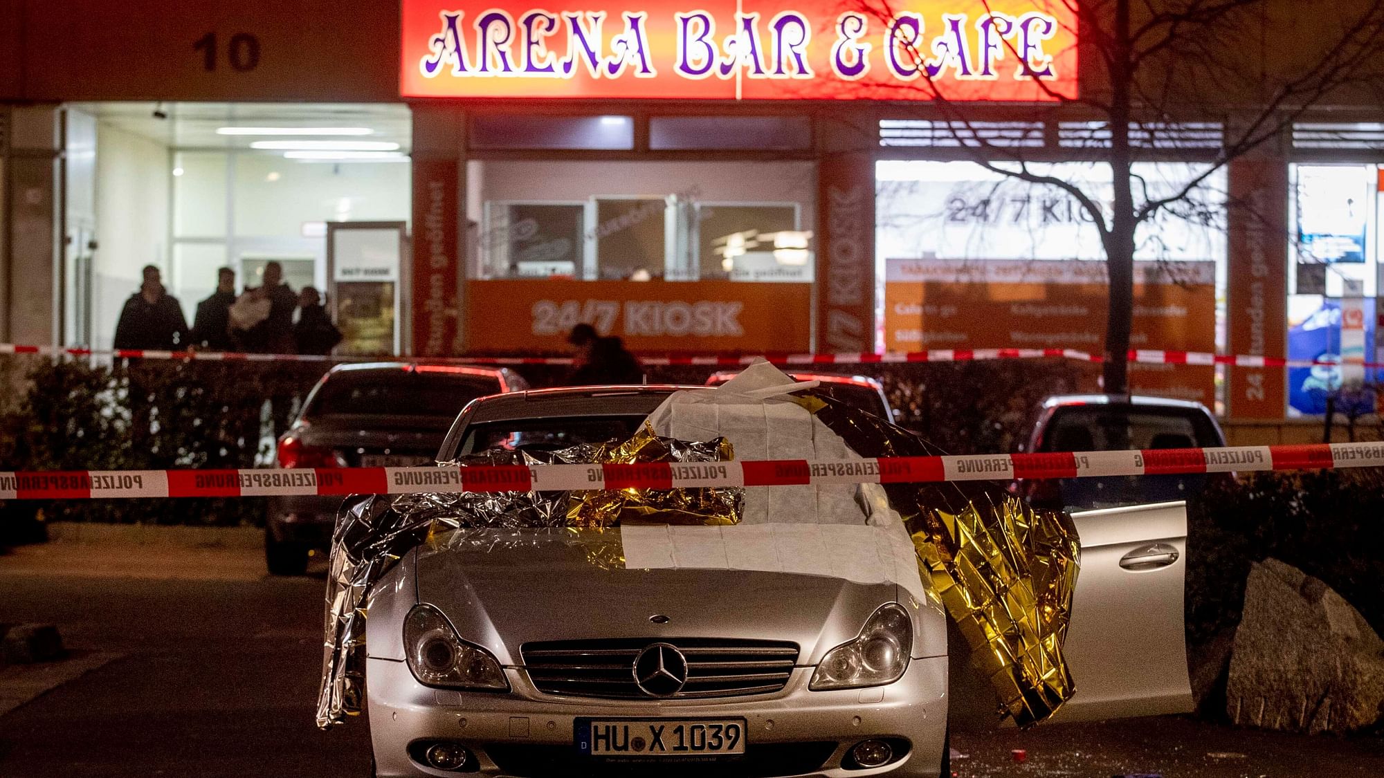 A car with dead bodies stands in front of a bar in Hanau, Germany, Thursday, Feb. 20, 2020.