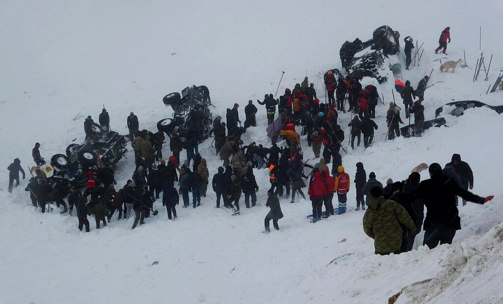 Emergency service members work in the snow around overturned vehicles, near the town of Bahcesaray, Van province, eastern Turkey, Wednesday, 5 February.