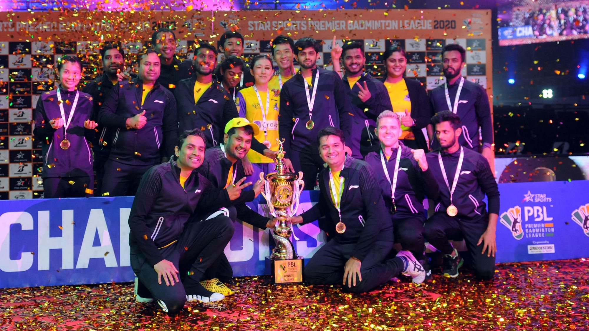 Members of the Bengaluru Raptors squad pose with the Premier Badminton League trophy after they edged past North Eastern Warriors 4-2 in the final on Sunday.
