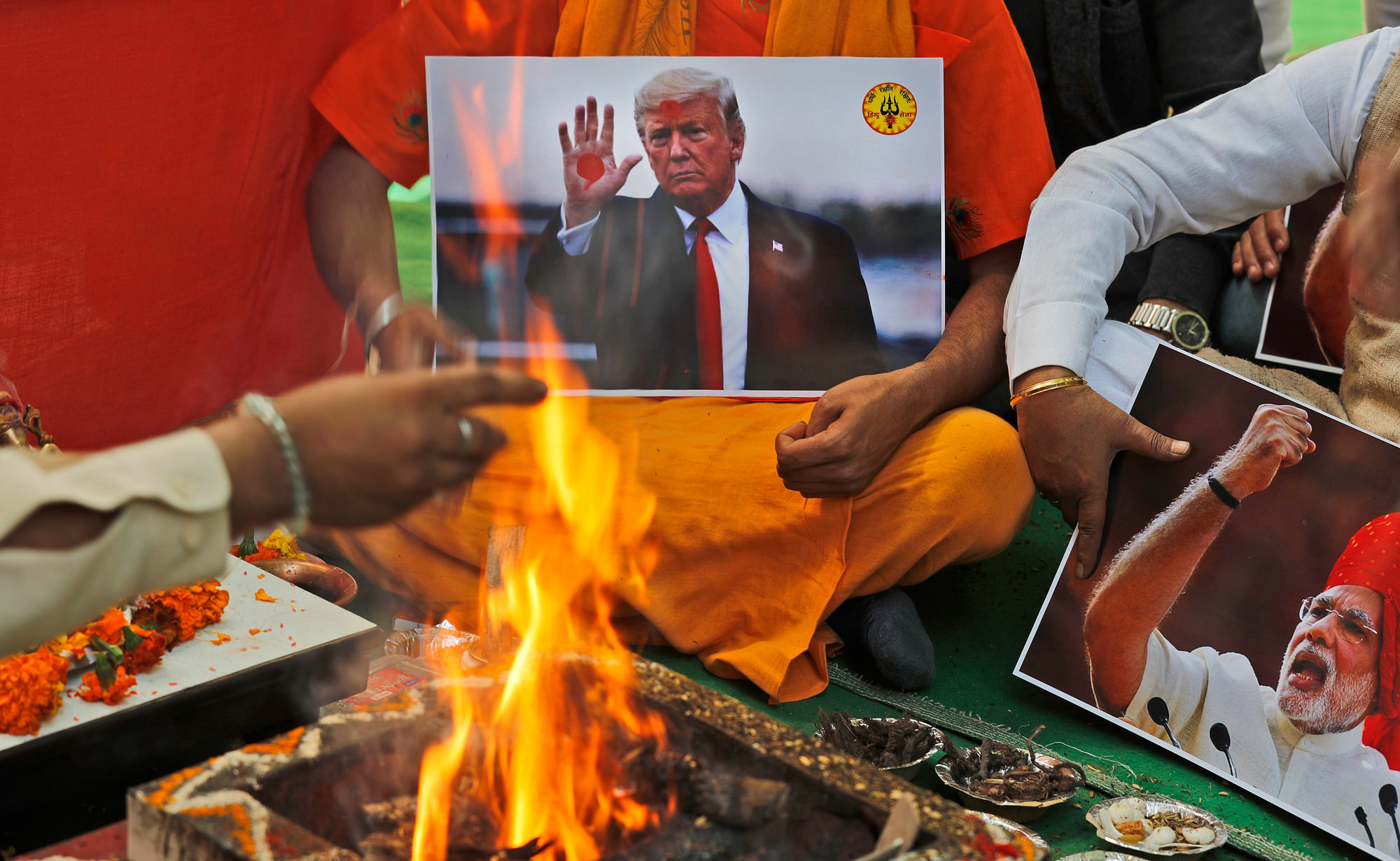 A Hindu priest offers prayers holding portraits of Indian Prime Minister Narendra Modi and U.S. President Donald Trump in New Delhi, India. The prayer event was held by Hindu Sena for a successful Trump win. 
