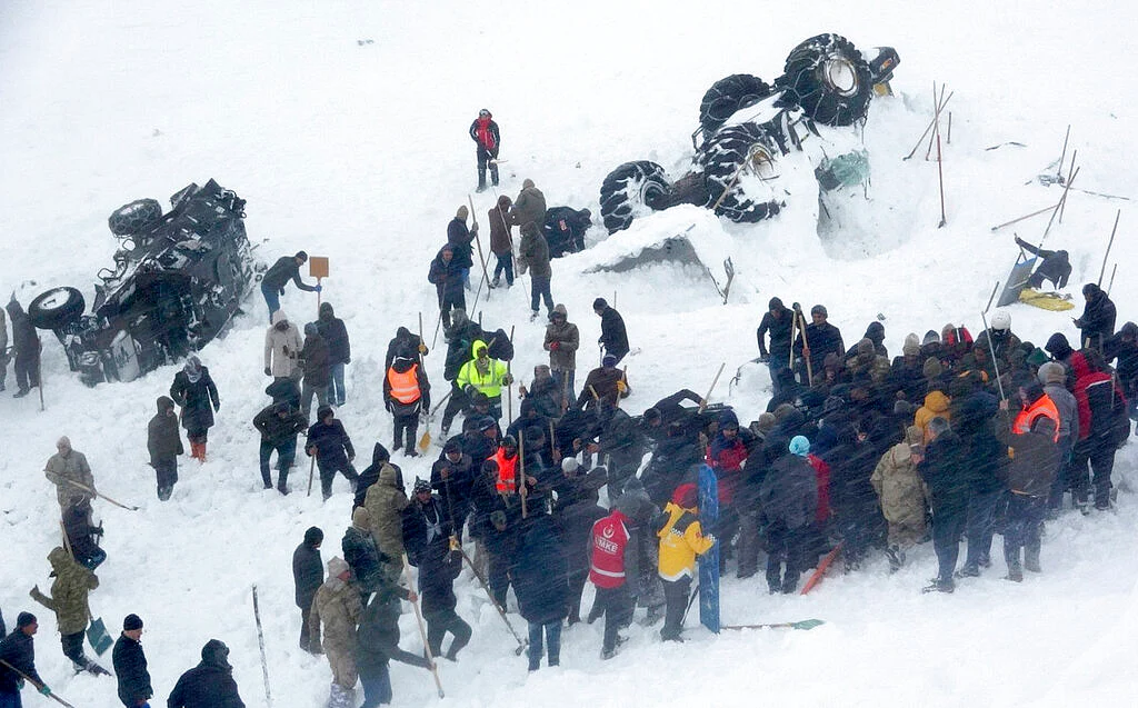 Emergency service members work in the snow around overturned vehicles, near the town of Bahcesaray, Van province, eastern Turkey, Wednesday, 5 February.