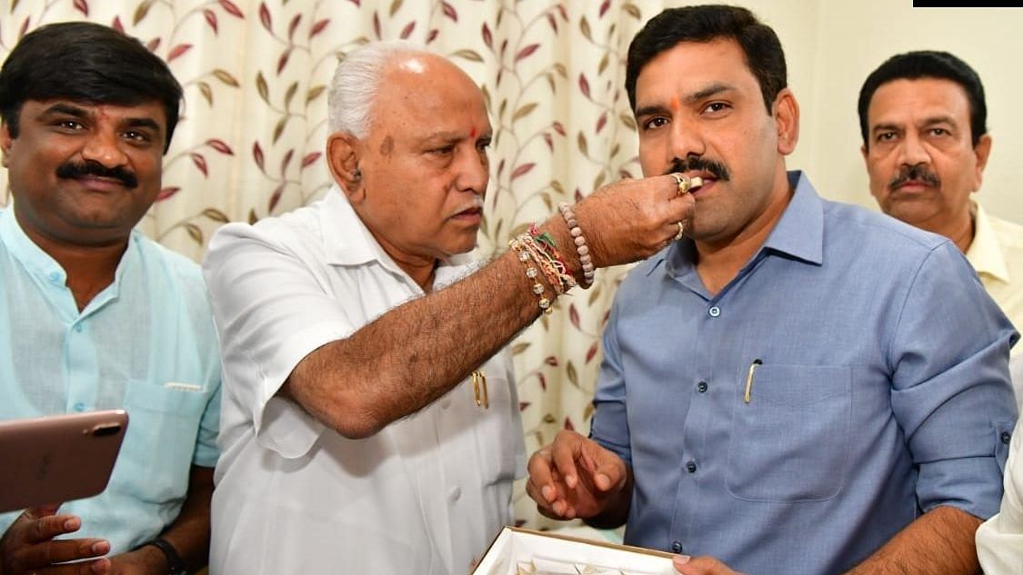 Karnataka Chief Minister BS Yediyurappa celebrates with his son BY Vijayendra.&nbsp;