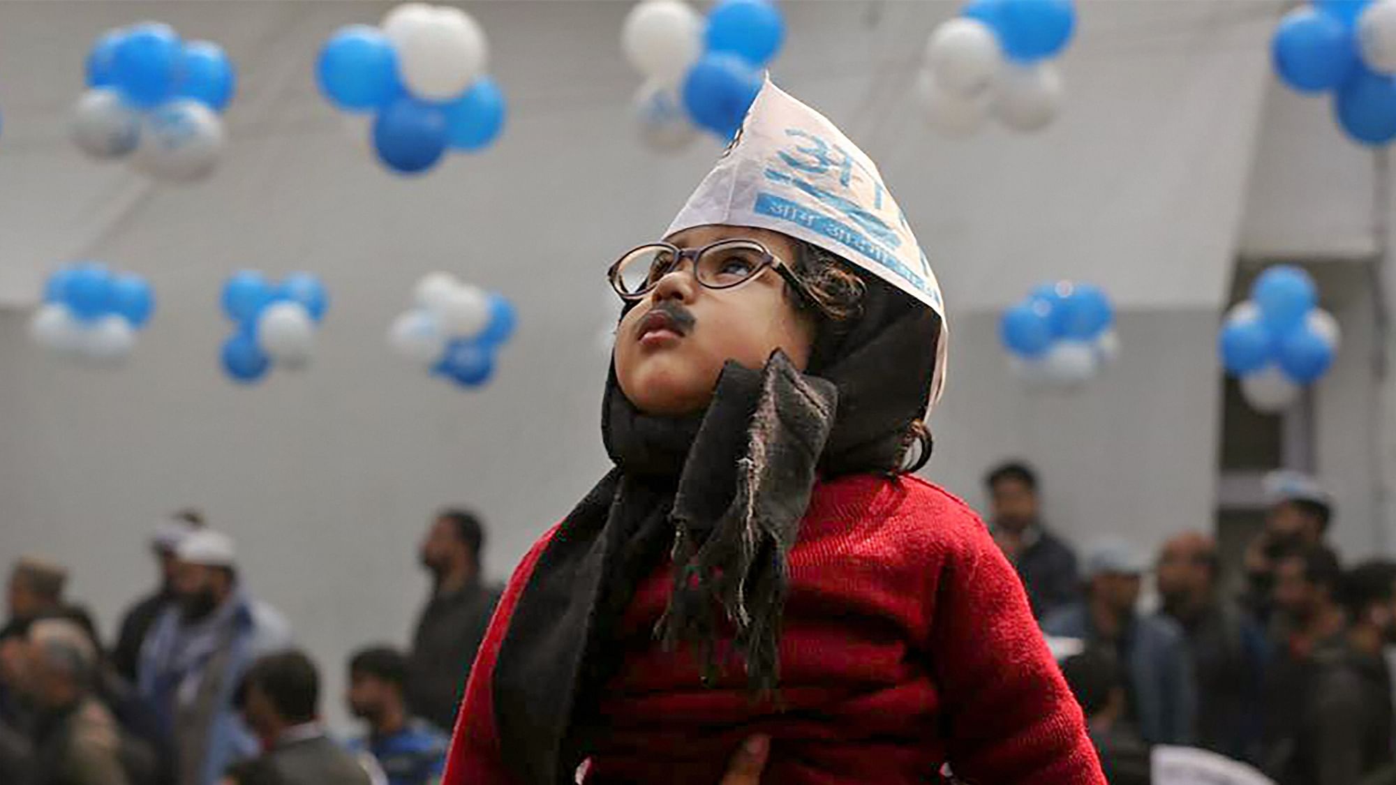  Aam Aadmi Party workers hold a child dressed as AAP convener Arvind Kejriwal as they celebrate the party’s victory in the Delhi Assembly polls, at party headquarters in New Delhi, on Tuesday, 11 February.&nbsp;