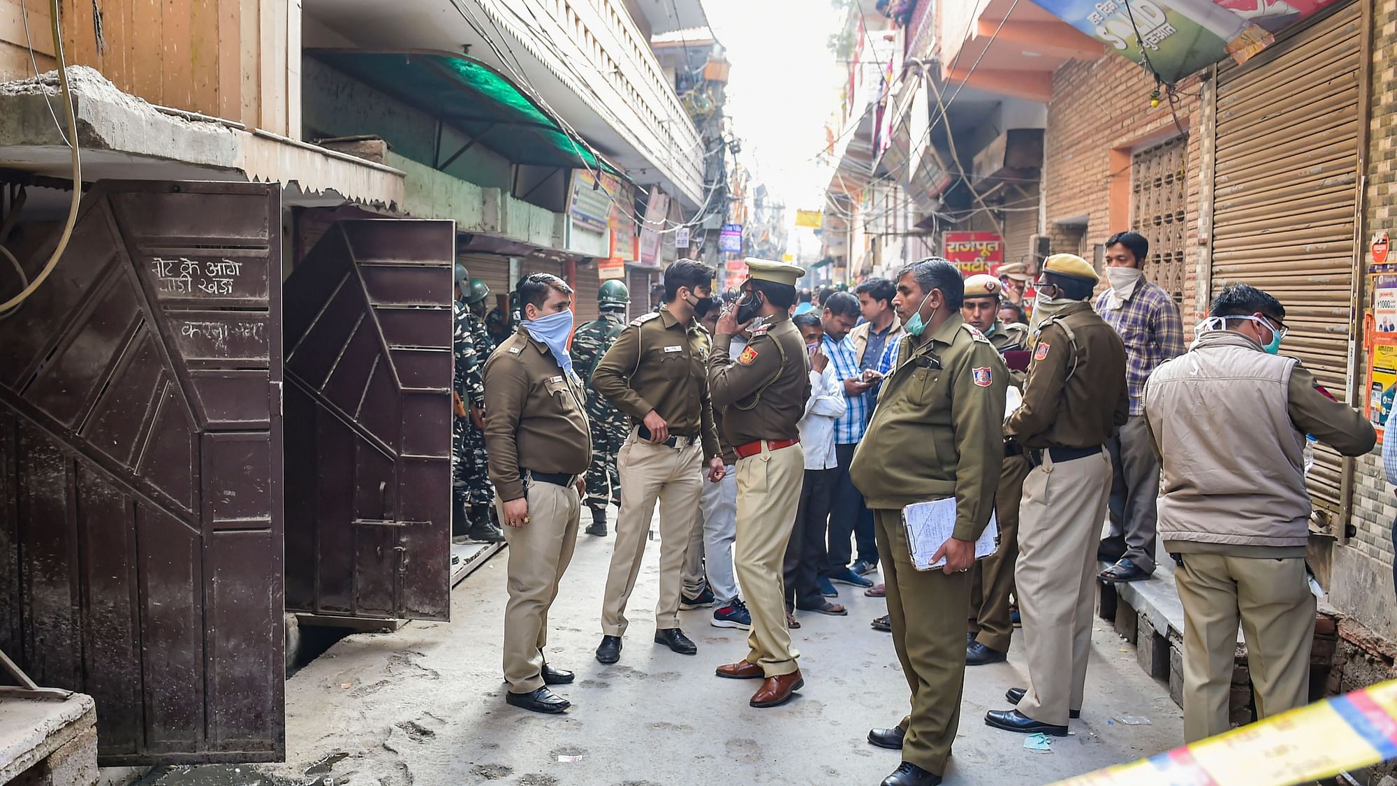  Police personnel stand outside a house where five members of a family were found dead at Bhajanpura area of New Delhi, Wednesday, 12 February.&nbsp;