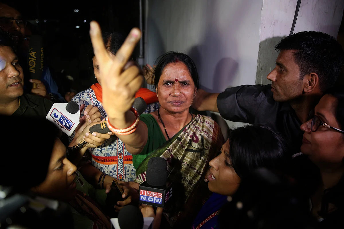 Asha Devi, mother of the victim of the fatal 2012 gang rape on a moving bus, displays a victory sign after the rapists of her daughter were hanged in New Delhi, India, Friday, 20 March 2020.