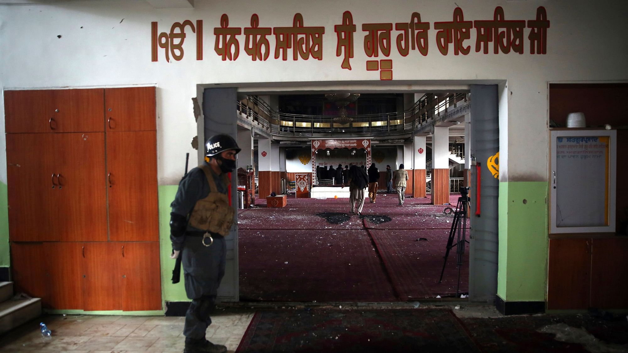 An Afghan policeman stands guard at the entrance of the gurudwara.