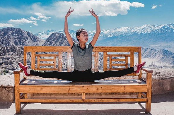 Girl performs with Himalayas in the background.