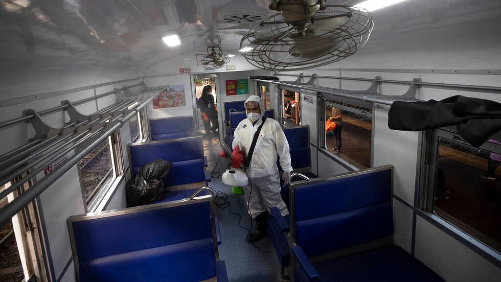 A Thai worker disinfects inside a train to avoid the spread of the new coronavirus at Hua Lamphong Railway Station in Bangkok, Thailand