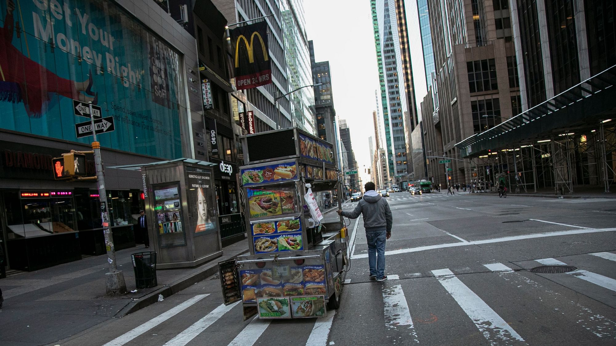 A food truck vendor pushes his cart down an empty street near Times Square in New York, on Sunday, 15 March 2020. 
