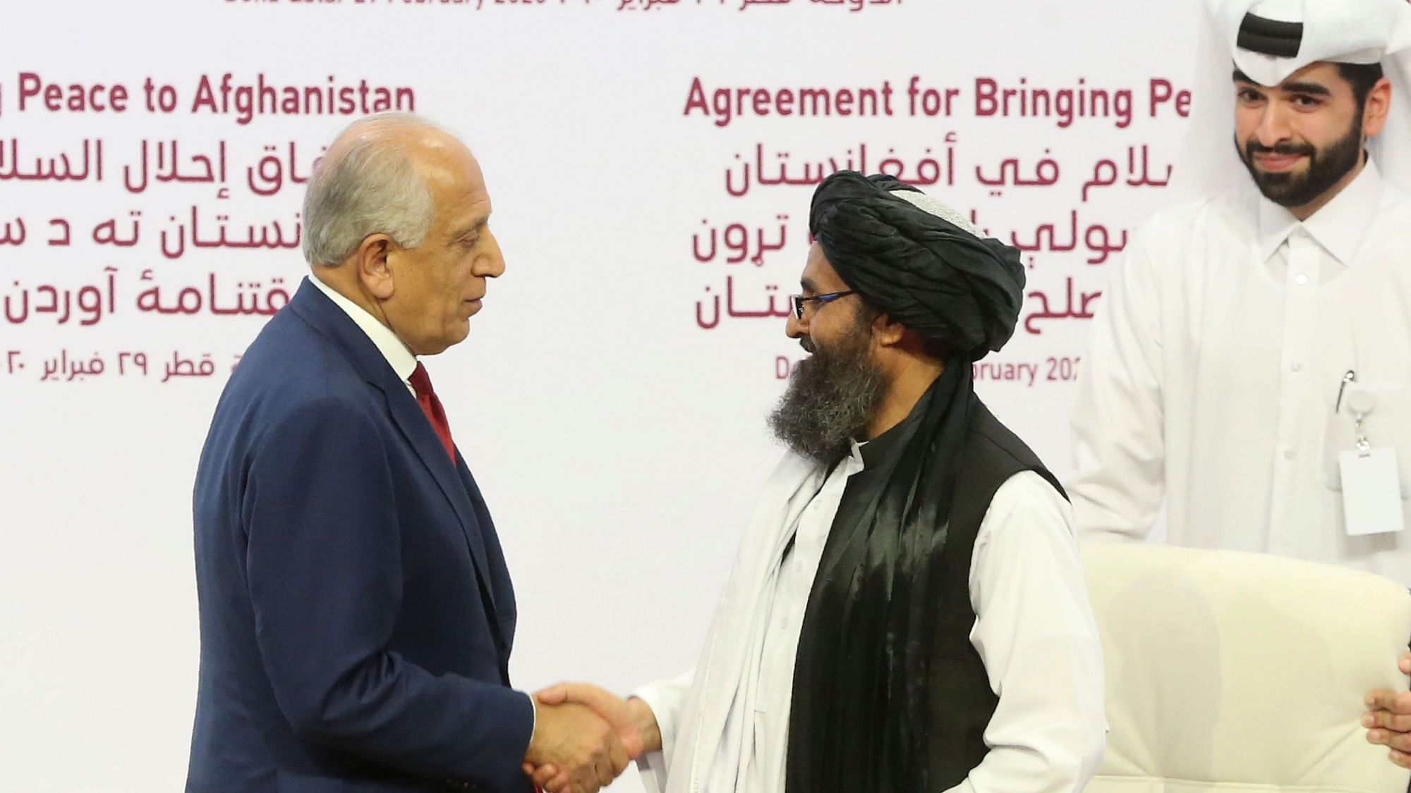 US peace envoy Zalmay Khalilzad, left, and Mullah Abdul Ghani Baradar, the Taliban group’s top political leader shake hands after signing a peace agreement between Taliban and US officials in Doha, Qatar, on 29 February.