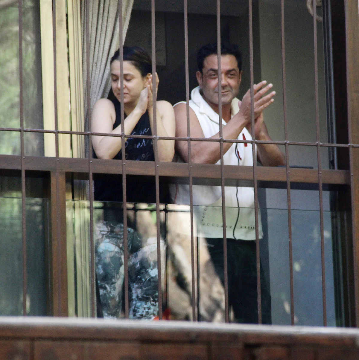 Bobby Deol claps with the crowd.