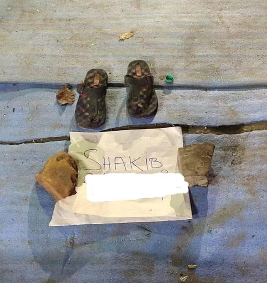A protestor leaves their shoes and a piece of paper with their name on it at the Park Circus protest venue.