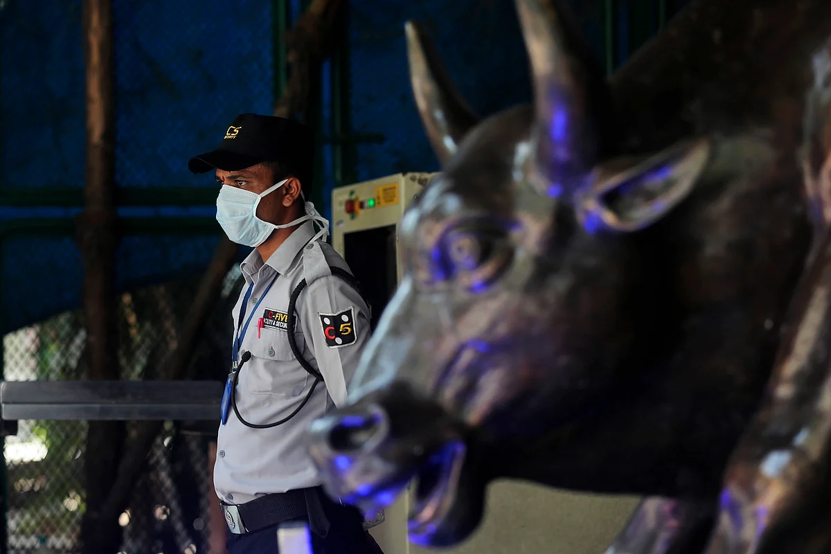 A security guard wearing a mask as a precaution against the new coronavirus stands at the Bombay Stock Exchange (BSE) building in Mumbai, in Mumbai, India, Monday, 16 March 2020.