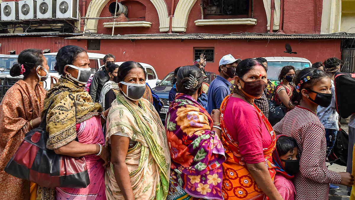 Passengers stand in queue to be screened at Howrah station during ‘Janata Curfew’, in Kolkata, on Sunday, 22 March.