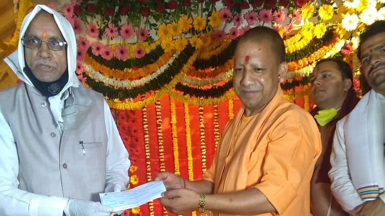 Champat Rai (left), who is general secretary of the Ram Mandir trust and senior VHP leader, is seen along with UP CM Yodi Adityanath. Here, the chief minister is seen handing over a Rs 11 lakh cheque to Champat Rai.