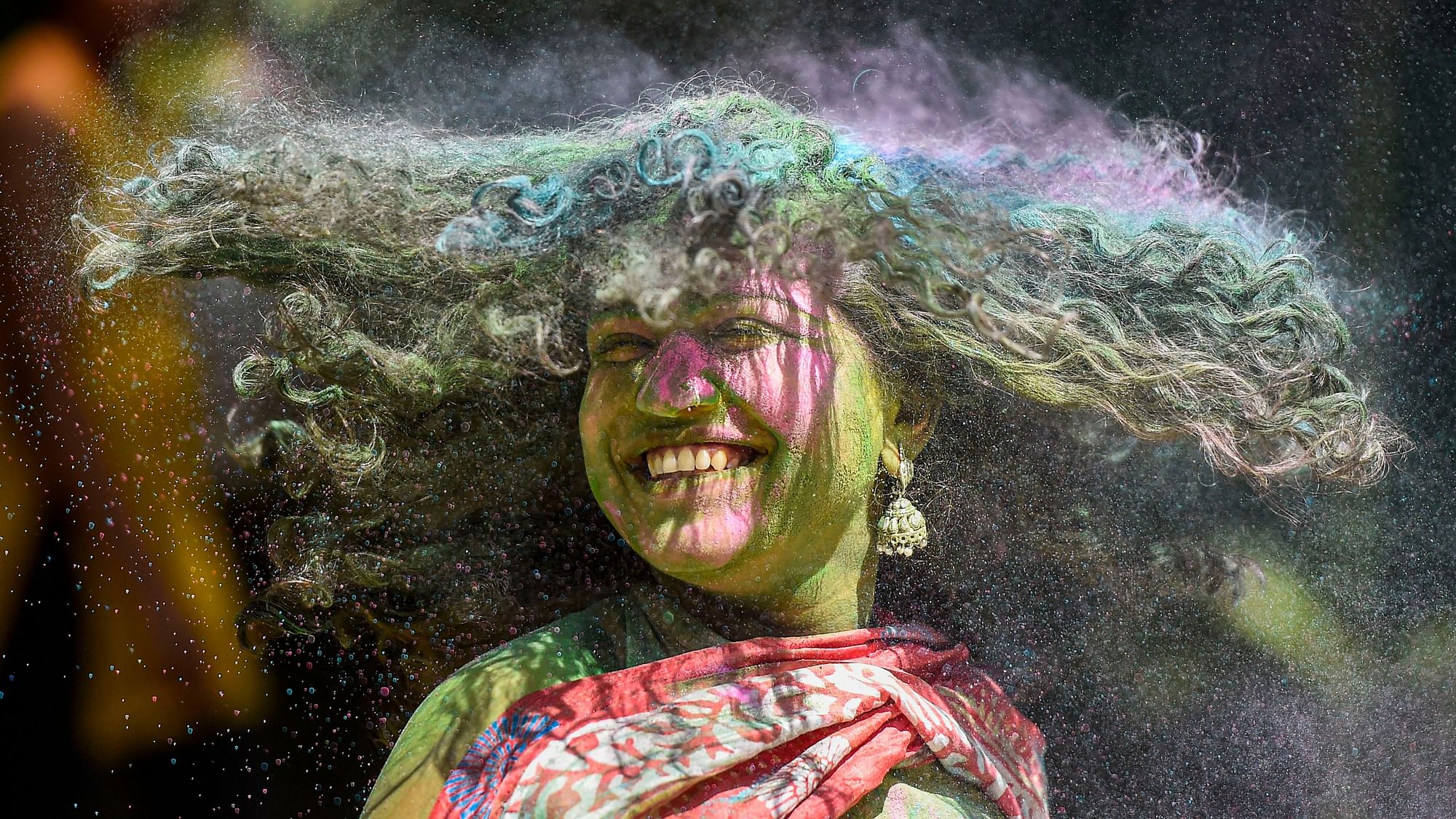 A reveller smeared in colour powder celebrates Holi, the spring festival of colours, in Mumbai, Tuesday, 10 March 2020.