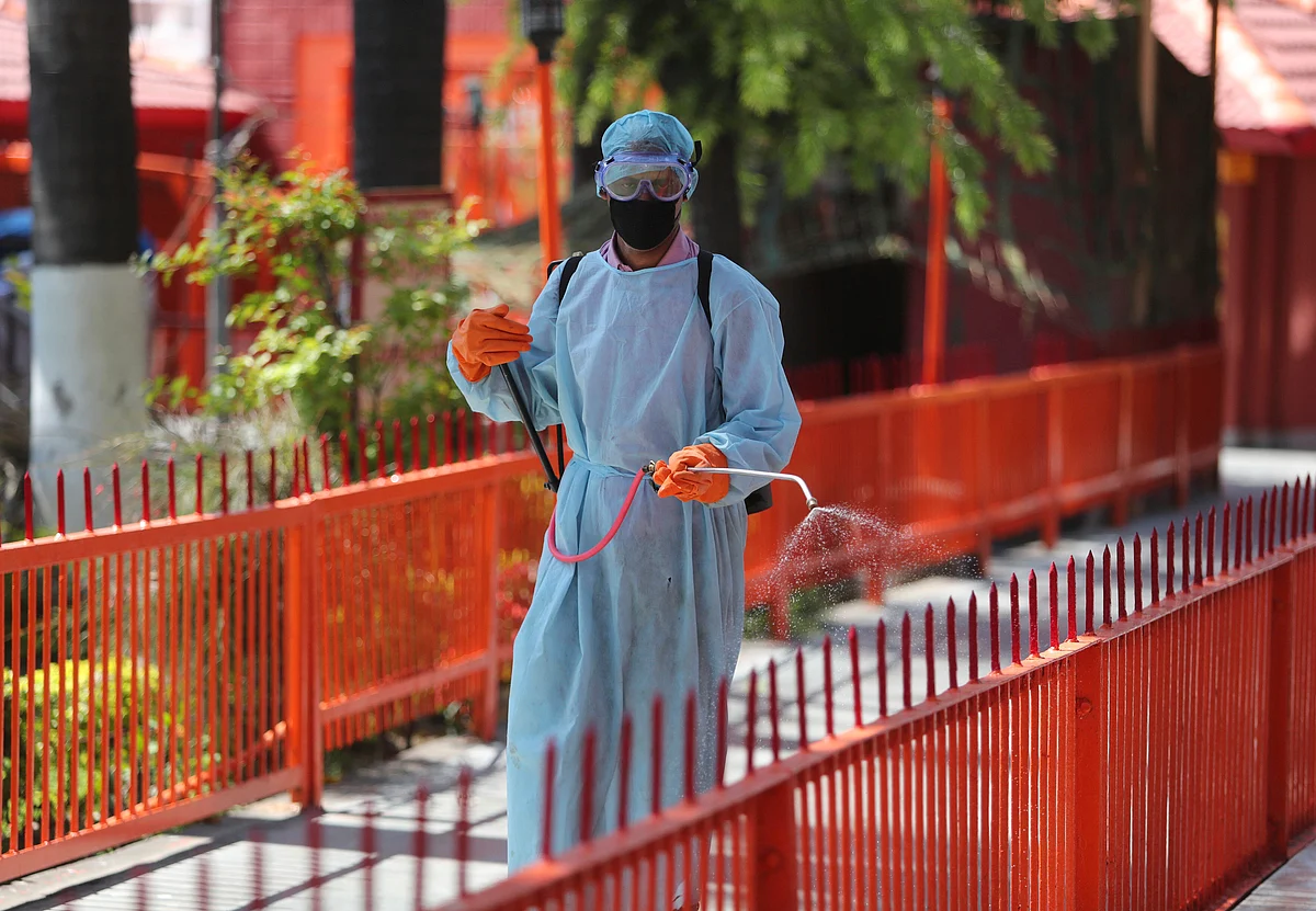 A municipal worker spray disinfectants as a precautionary measure against COVID-19 outside a temple in Jammu, India, Friday, 20 March 2020.