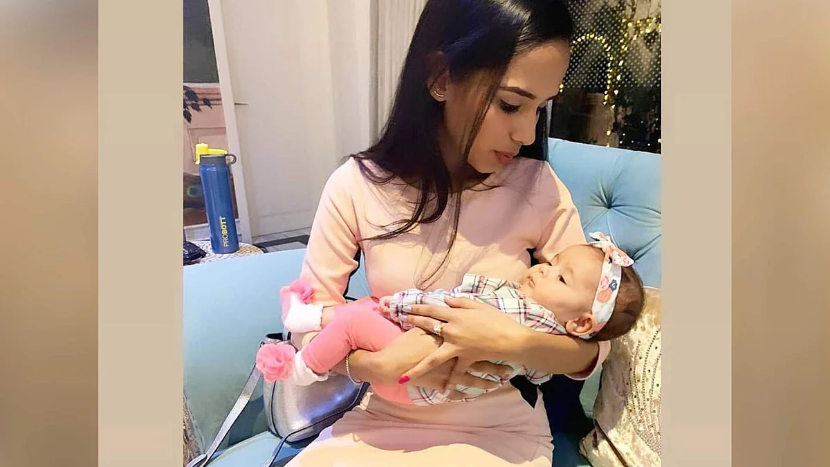 A friend of Kapil Sharma and Ginni Chatrath cradles their daughter Anayra.