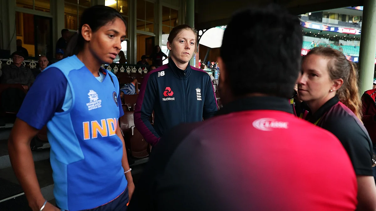 Captains Harmanpreet Kaur of India and Heather Knight of England speak to umpires before play was abandoned due to rain during the ICC Women’s T20 Cricket World Cup Semi Final.