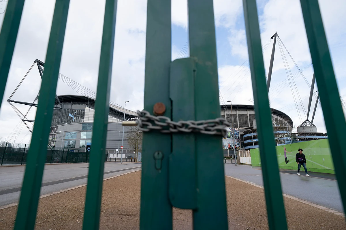 A locked gate is seen by the Etihad Stadium where Manchester City was due to play Burnley in an English Premier League match Saturday March 14, 2020.