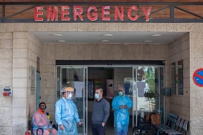 Health staff wearing protective masks standing at the emergency entrance of a Hospital.