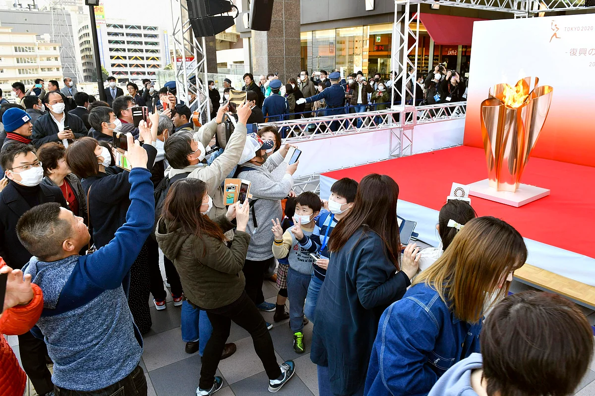 People gather to take a look at Olympic flame on display in Sendai, Miyagi prefecture, north of Tokyo Saturday, March 21, 2020.