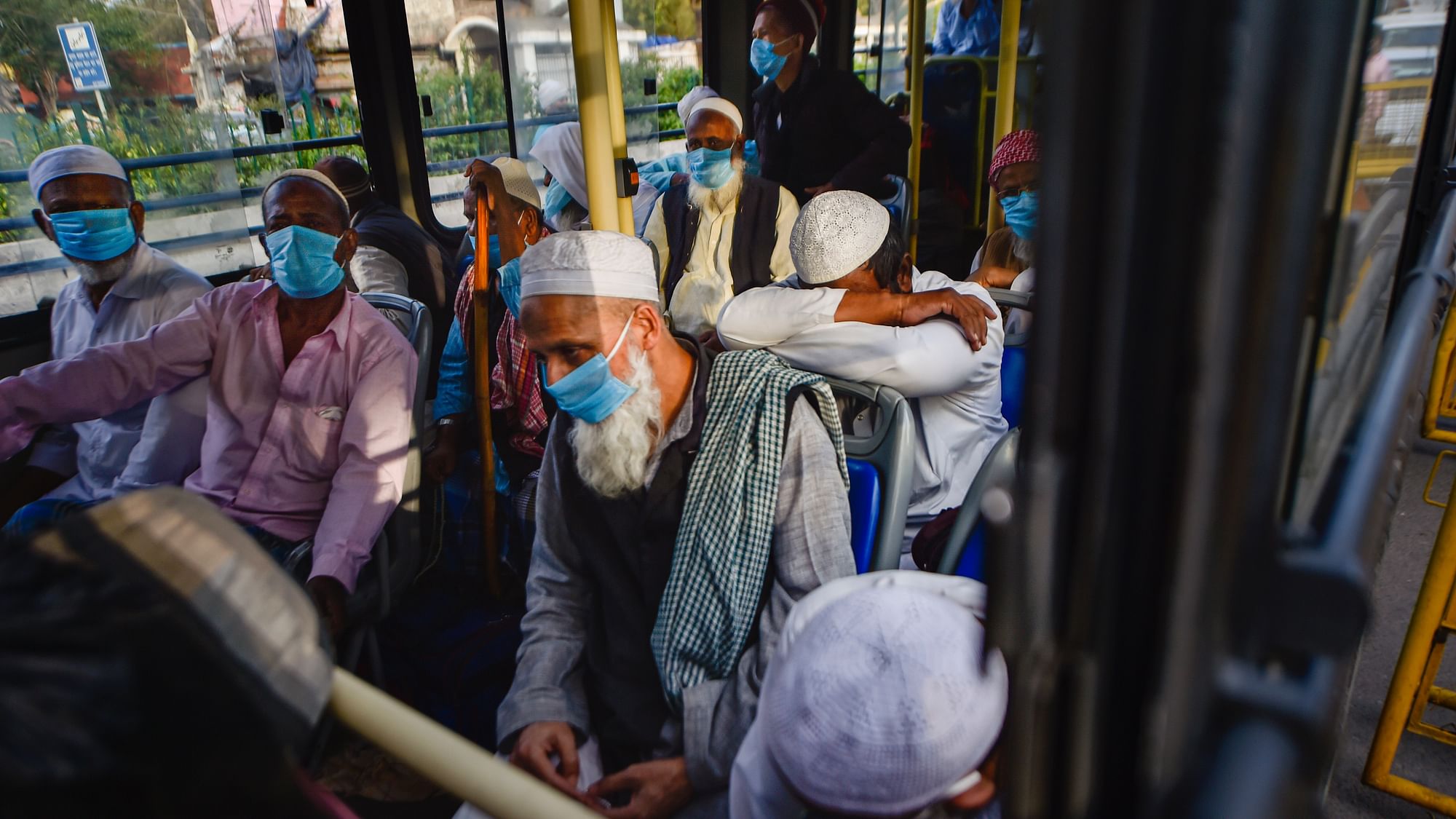 People wearing masks leave for hospital in a bus from Nizamuddin area, after several people showed symptoms of coronavirus following taking part in a religious gathering a few days ago, during the nationwide lockdown, in New Delhi, Monday, 30 March.