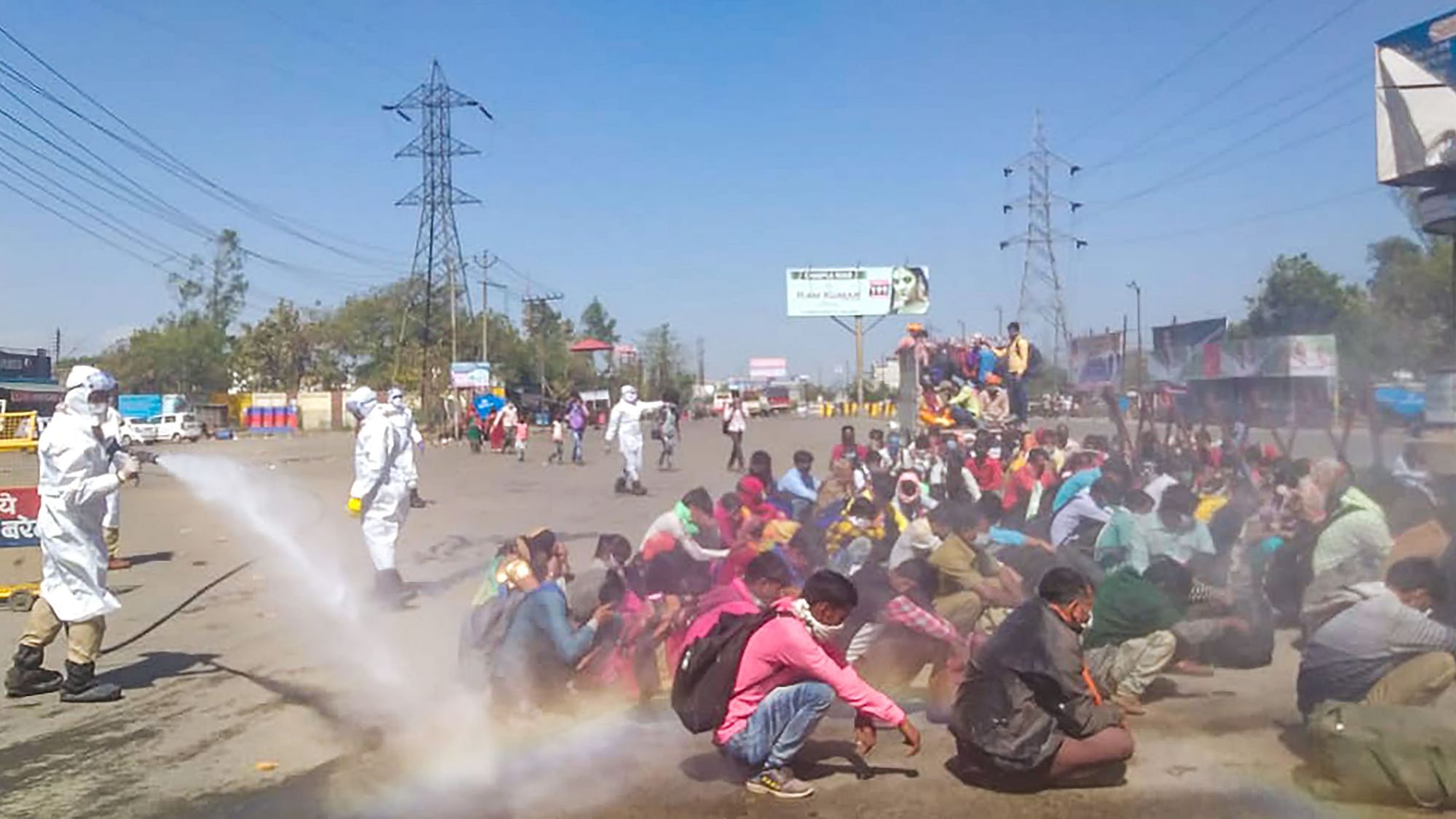 A screen grab shows healthcare workers spray a solution on migrants before allowing them to enter the town of Bareilly on 30 March.&nbsp;