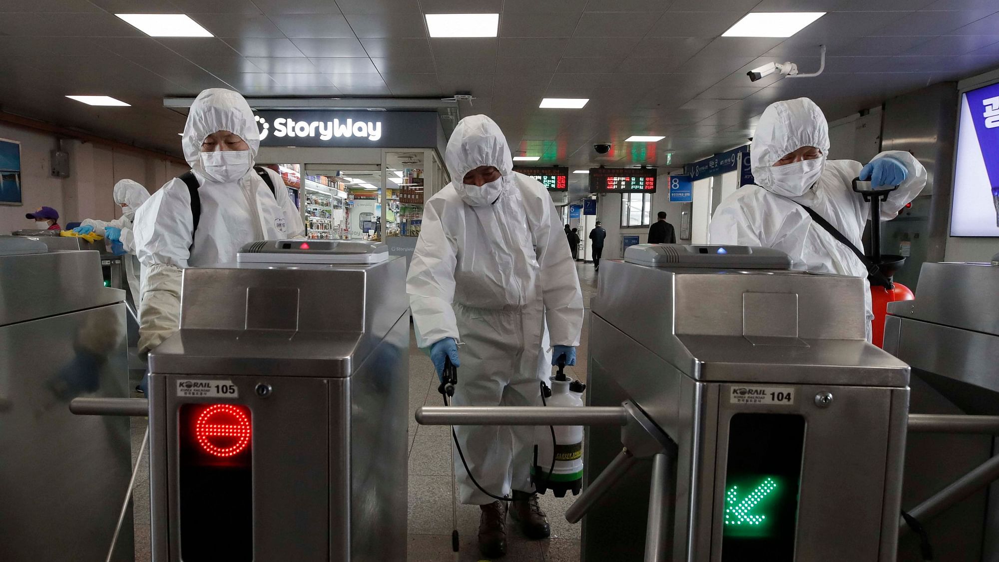 Workers wearing protective gears disinfect as a precaution against the new coronavirus at the subway station in Seoul, South Korea, Friday, March 13, 2020.