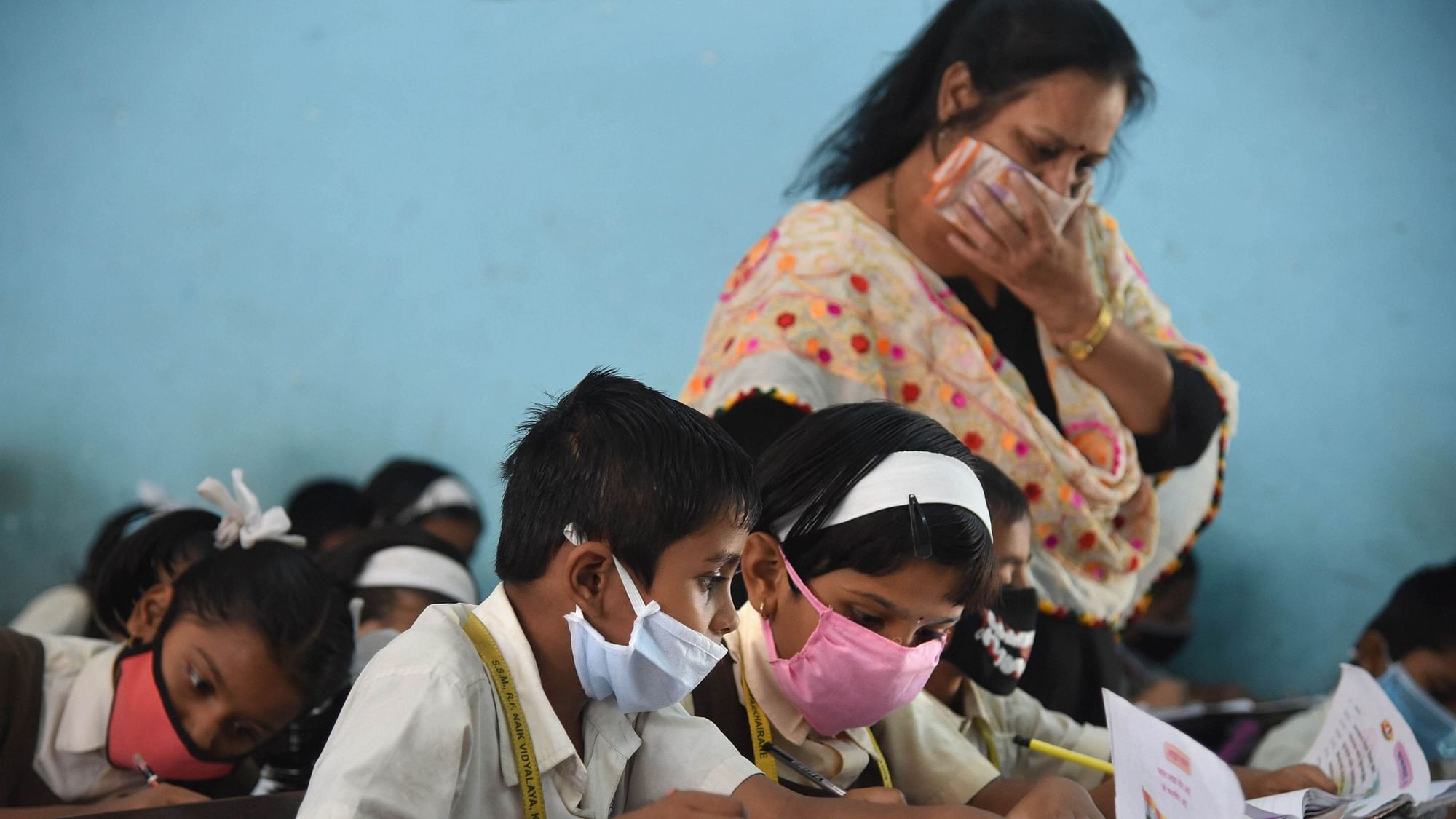 Students wearing masks in view of coronavirus pandemic attend a class, in Navi Mumbai, Saturday, March 14, 2020.