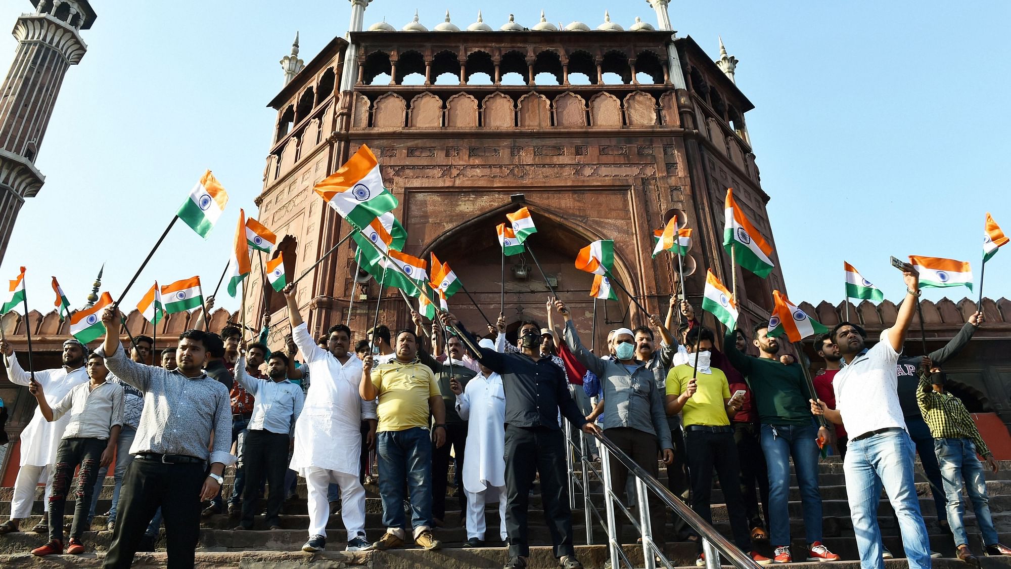 People hold the national flag and gather at Jama Masjid in Delhi during Janta Curfew in the wake of coronavirus.
