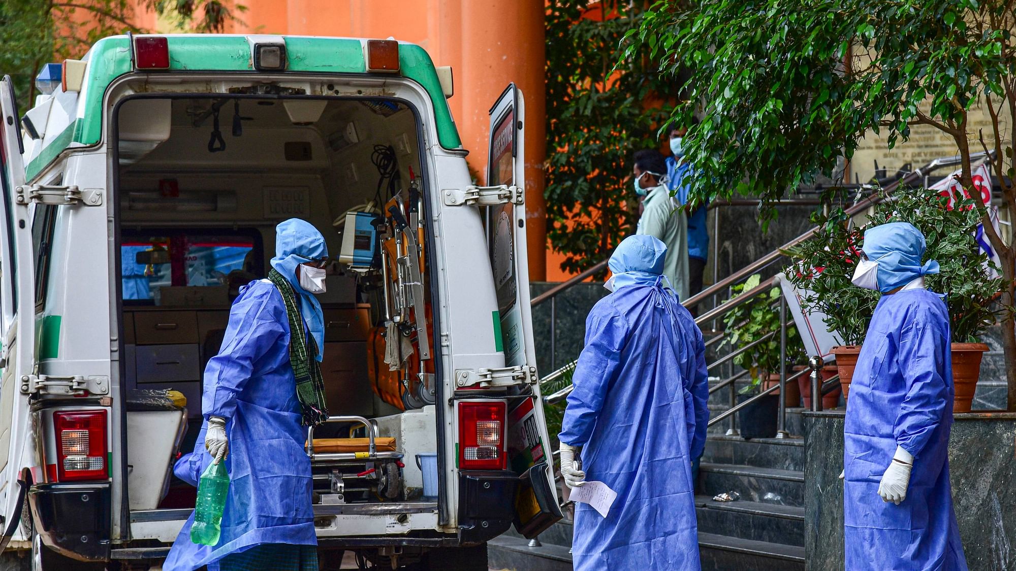 Medical workers attend to a suspected coronavirus patient (L), who travelled from Dubai, as he is moved to the isolation ward of Gandhi Hospital in Hyderabad.