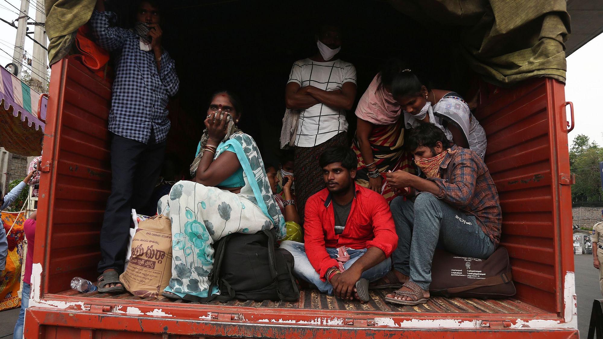 Indian migrants from Andhra Pradesh state, who were stopped while attempting to return to their native villages on foot, sit in a truck to be moved to a government facility during lockdown.