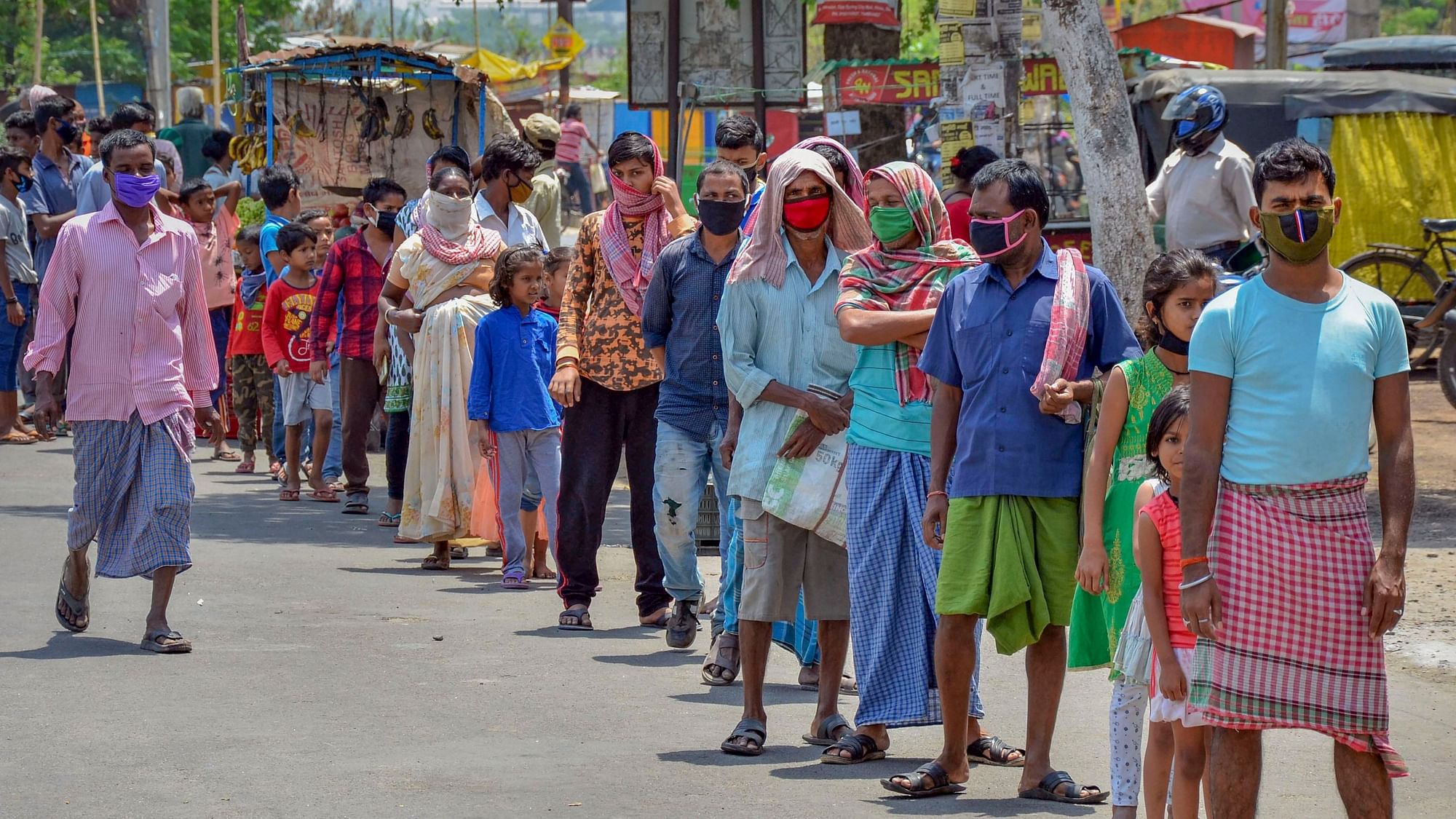 People stand in a queue to collect food from volunteers during the lockdown in Ranchi.&nbsp;