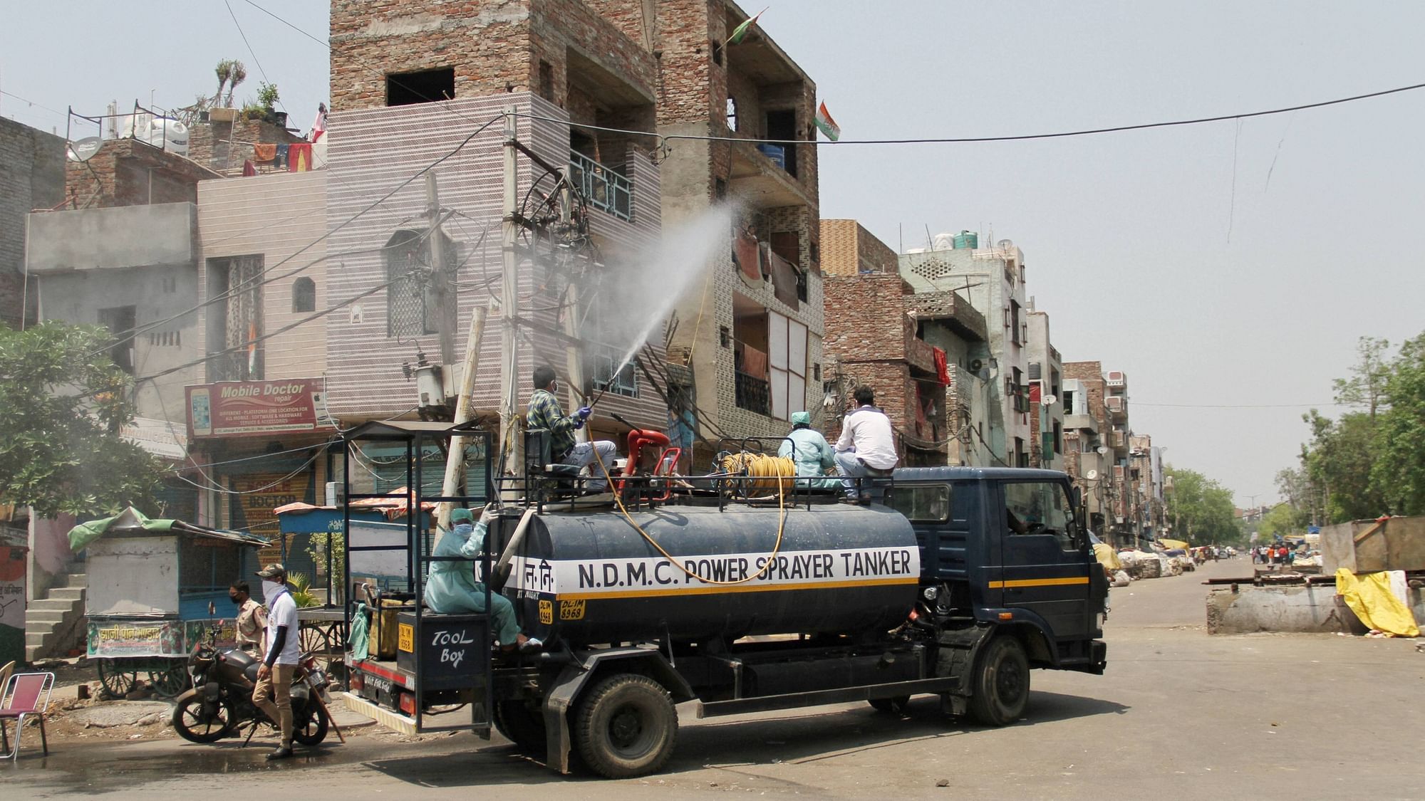 Workers sanitise a locality at Jahangirpuri during the lockdown to curb the spread of coronavirus, in Delhi on 24 April.