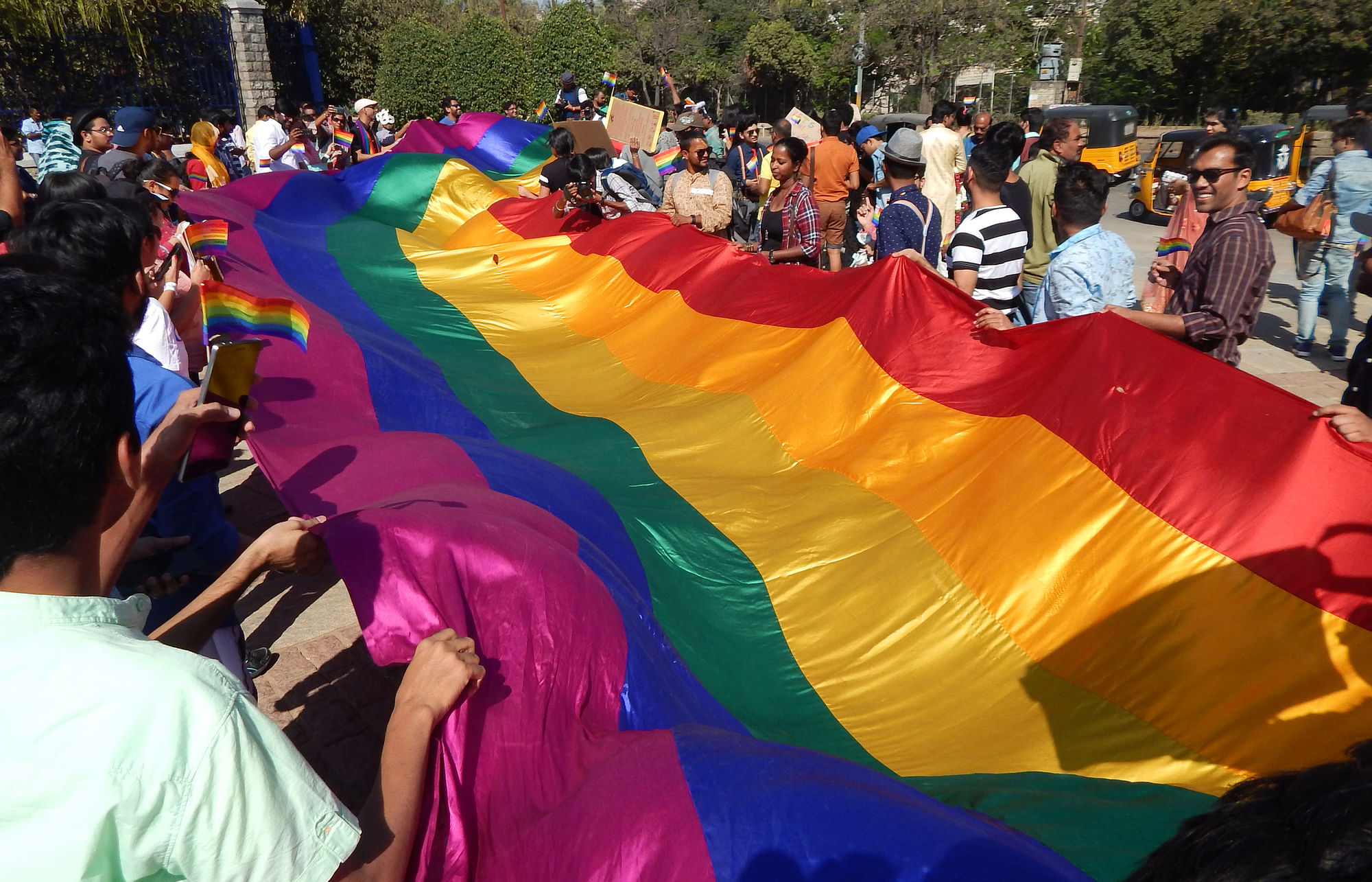 Indian LGBT activists holding a long rainbow flag