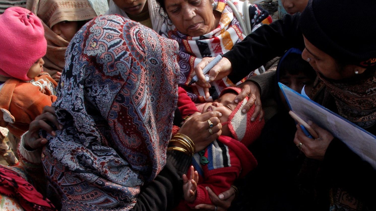 Health workers in UP giving Polio immunisation to a child