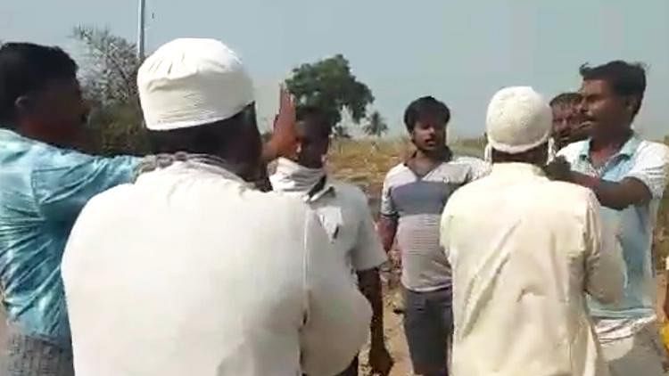Muslim men being heckled by villagers, accusing the community of spreading coronavirus.