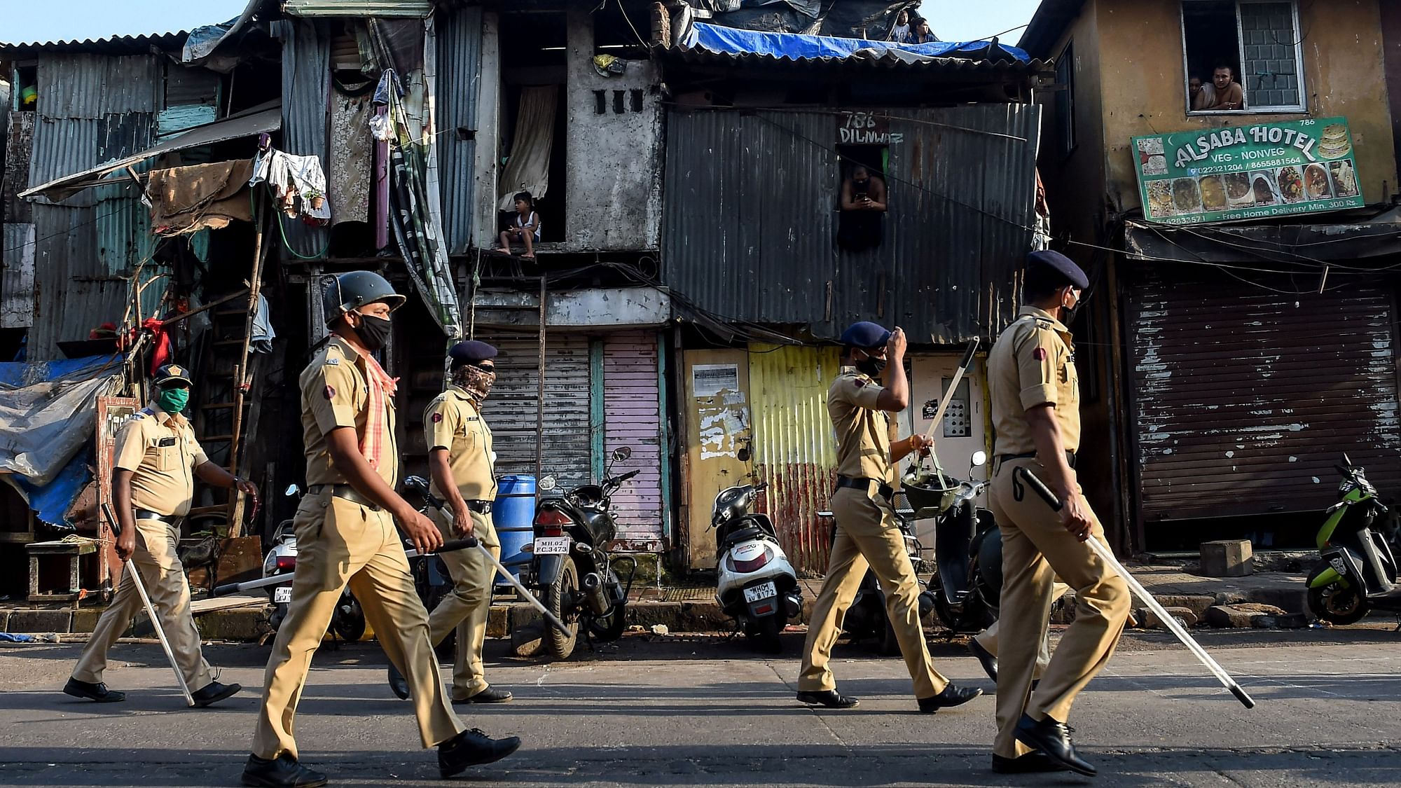 Police officers march on a street at Bandra during the coronavirus-lockdown in Mumbai, Sunday.