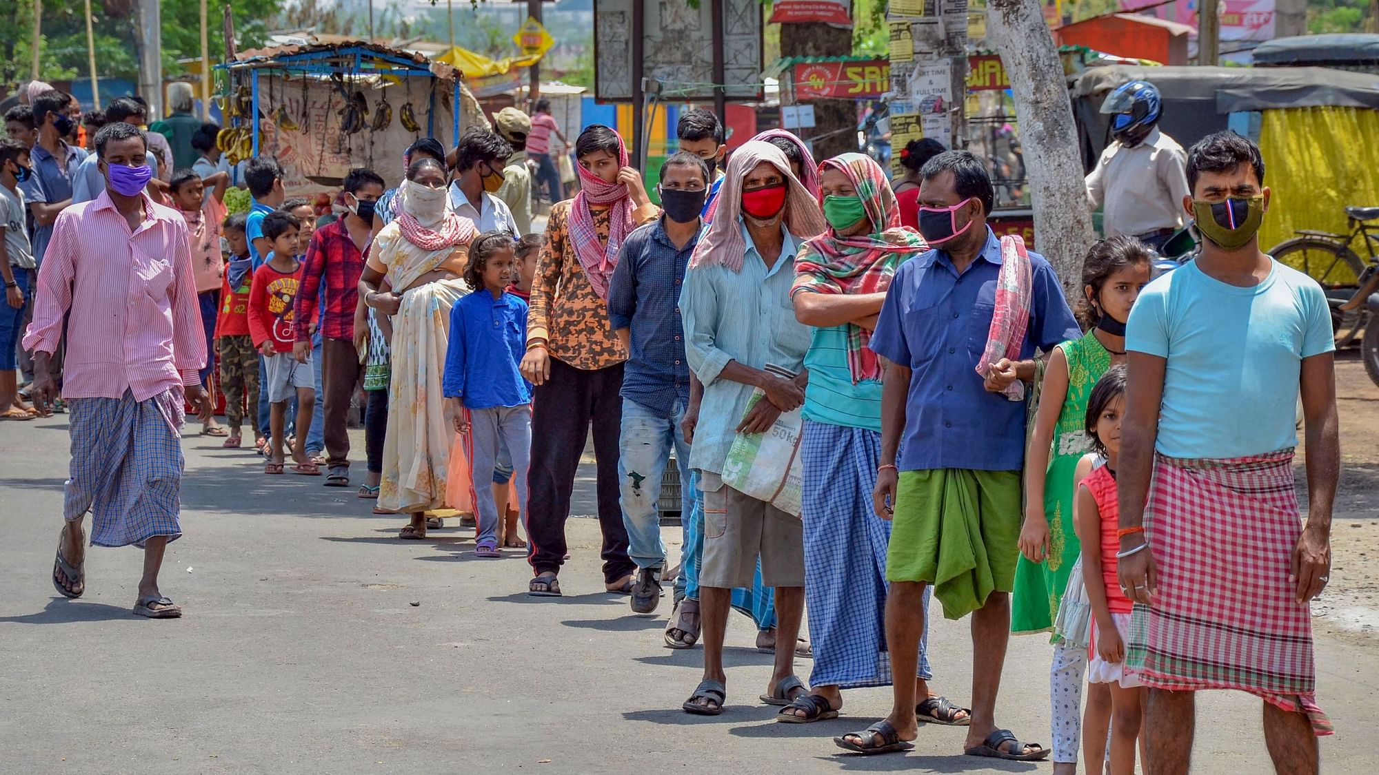 People stand in a queue to collect food from volunteers during the nationwide COVID-19 lockdown, in Ranchi on Wednesday, 15 April.