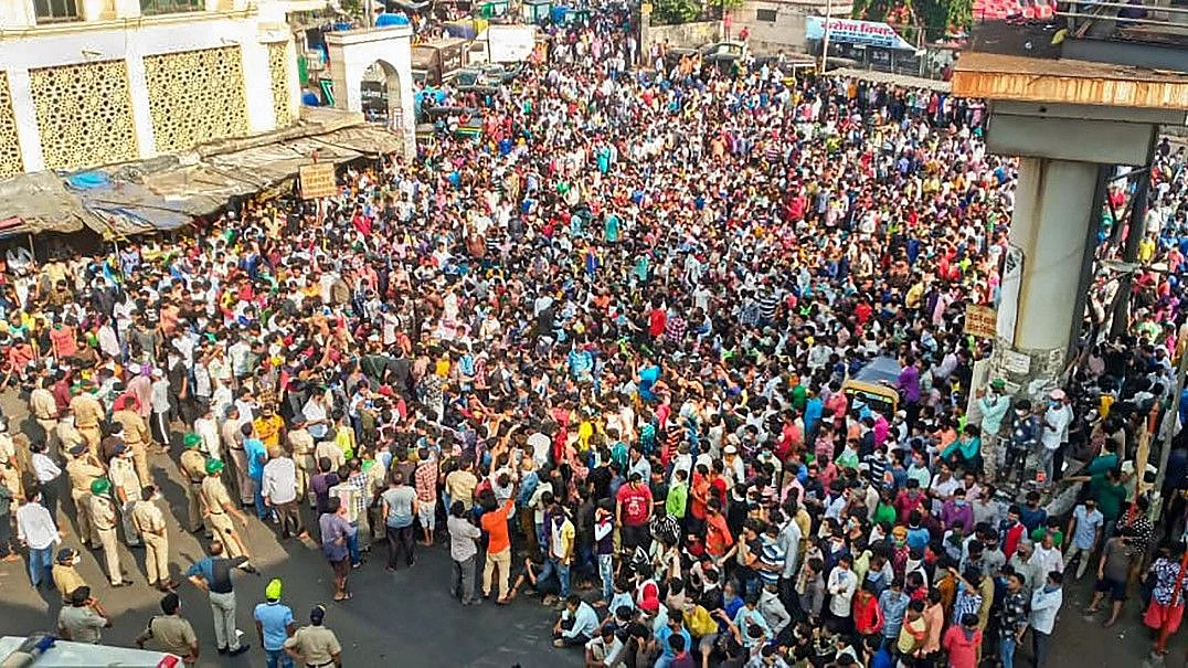 Migrant workers gather outside Bandra West Railway Station.