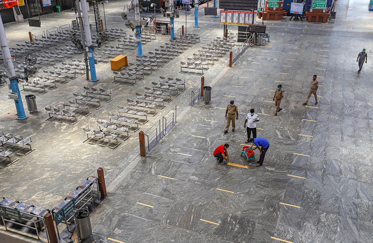 Chennai: Railway Protection Force personnel draw social distancing mark on a floor at Dr MG Ramachandran Central Railway station during a government-imposed nationwide lockdown. 