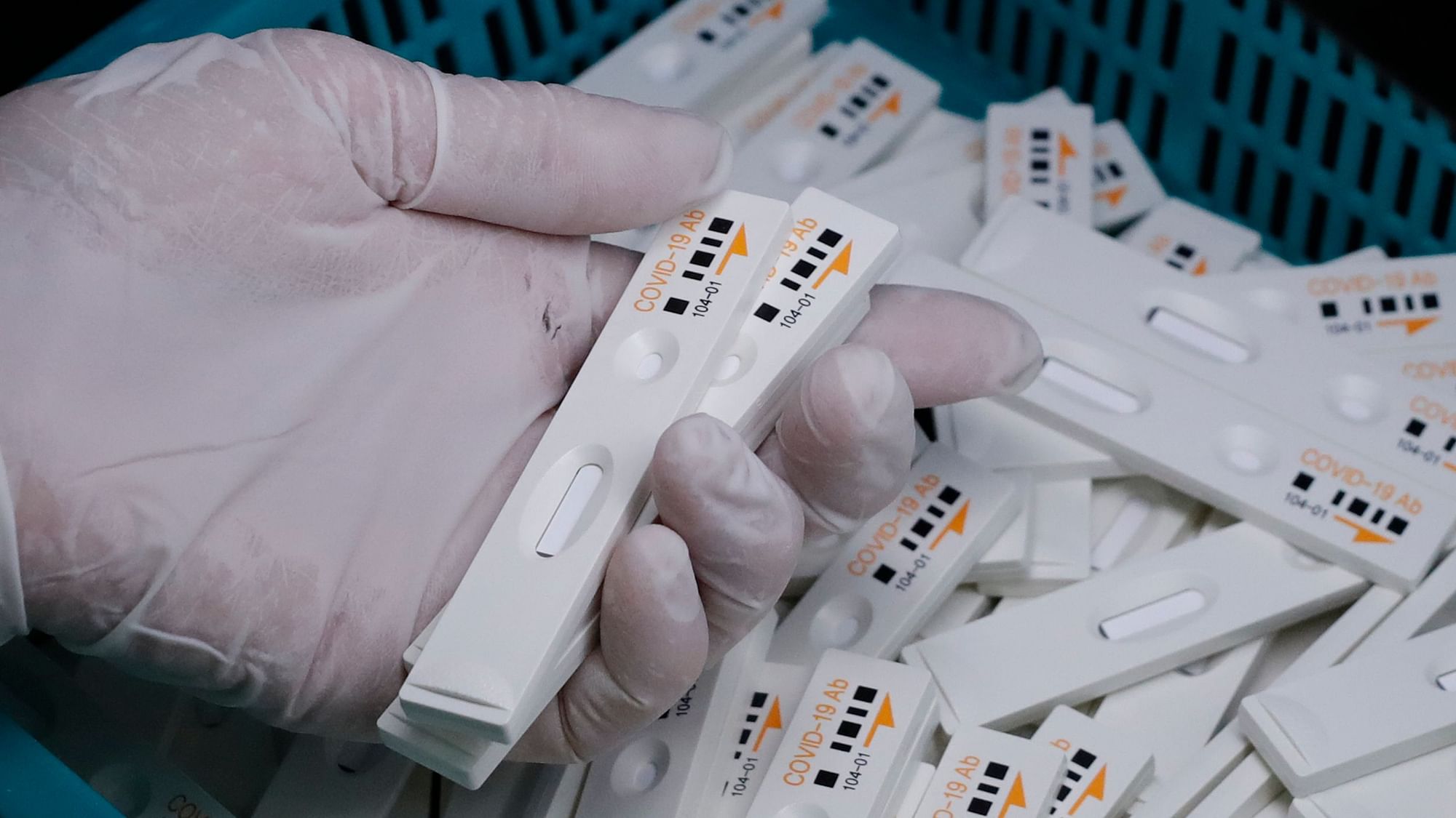 An employee holds antibody test cartridges of the ichroma COVID-19 Ab testing kit used in diagnosing coronavirus