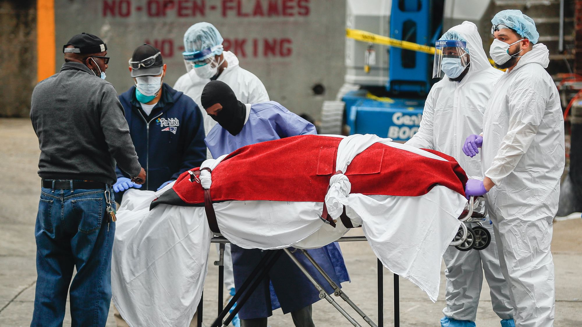 A body wrapped in plastic that was unloaded from a refrigerated truck is handled by medical workers wearing personal protective equipment due to COVID-19 concerns at Brooklyn Hospital Center in Brooklyn borough of New York.