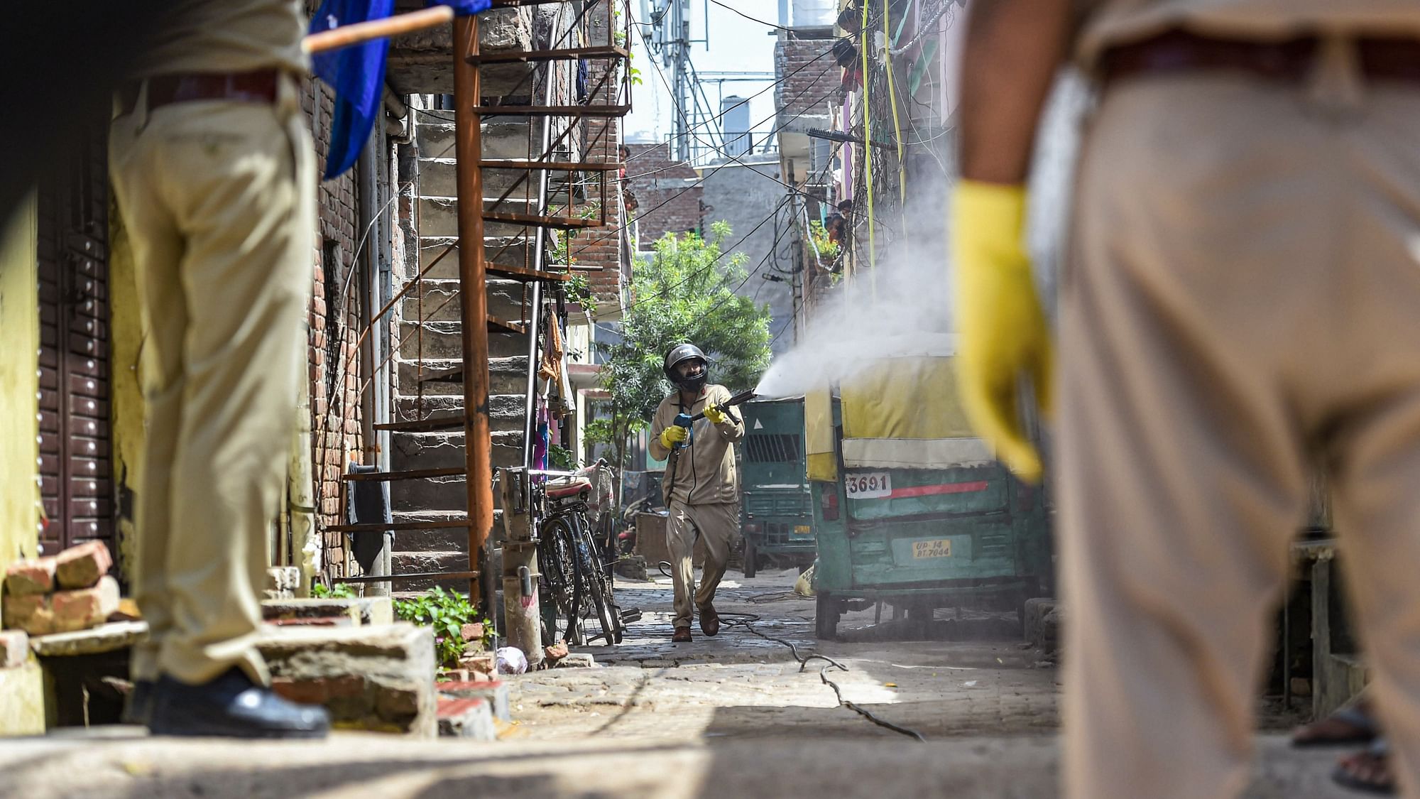 A worker sprays disinfectant at Nandgram village, marked as a COVID-19 hotspot, during the nationwide lockdown to curb the spread of coronavirus, in Ghaziabad, Thursday.