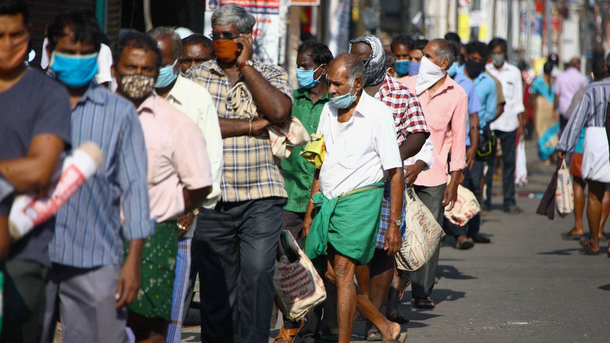 People stand in a queue to buy groceries and vegetables, during the  lockdown, in Coimbatore, Thursday.