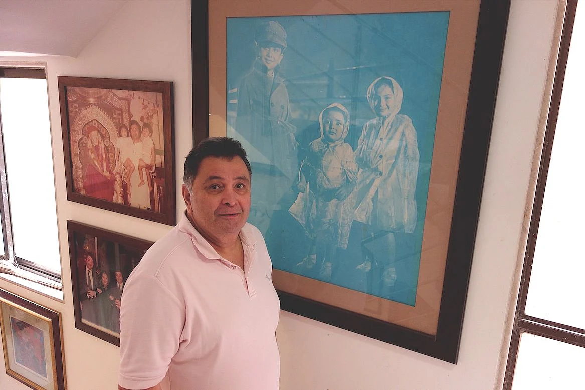 Rishi Kapoor at his residence standing beside a photo of his appearance as a child in <i>Shri 420.</i>