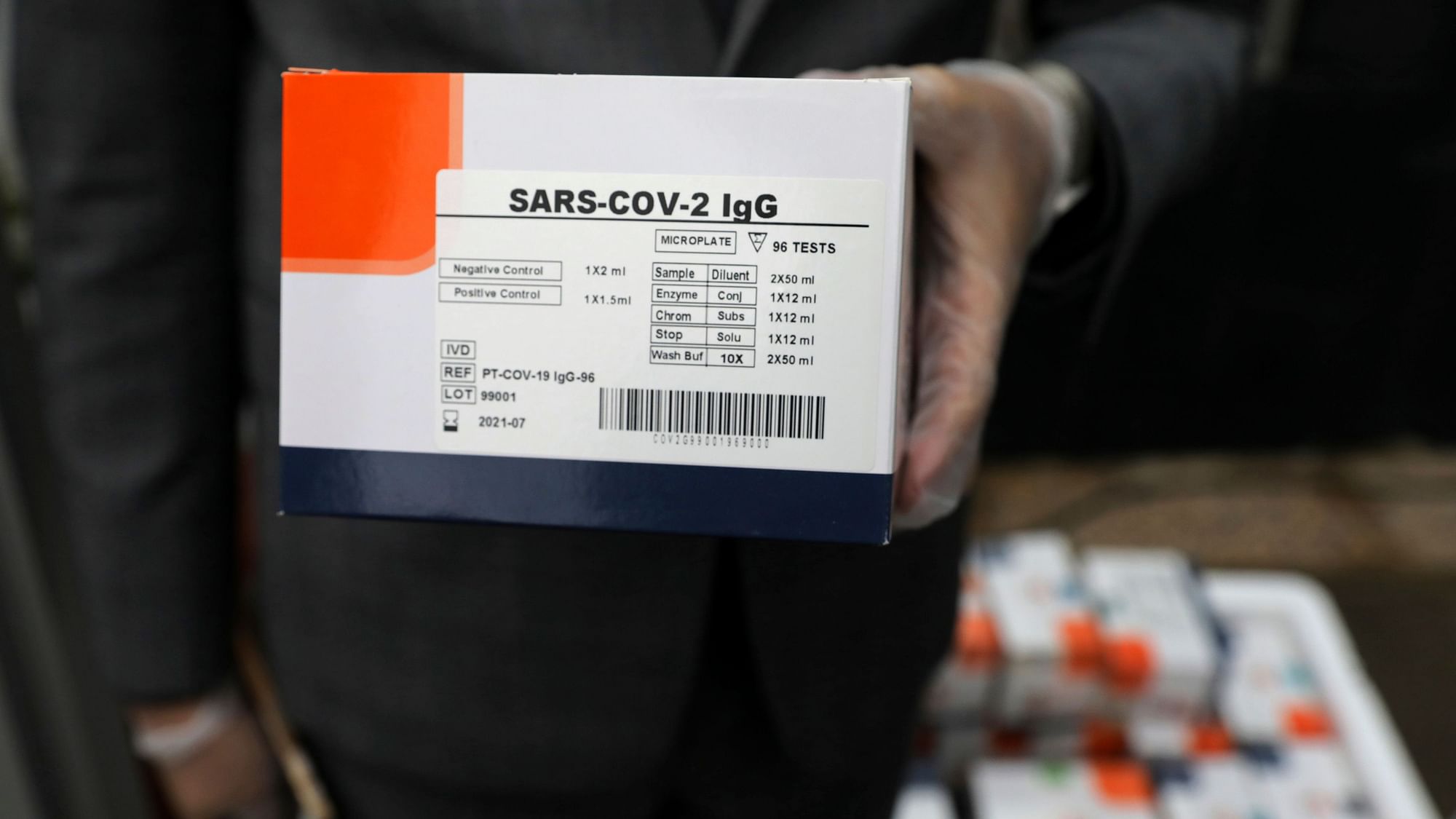 A medical firm staff holds a coronavirus testing kit.